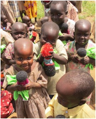 Agwata nursery school children smiling after receiving our gift of hand-knitted “Peace Dolls.” The dolls were donated by Chicks with Sticks and the Denver nonprofit Women for Women Knitting for Peace.
